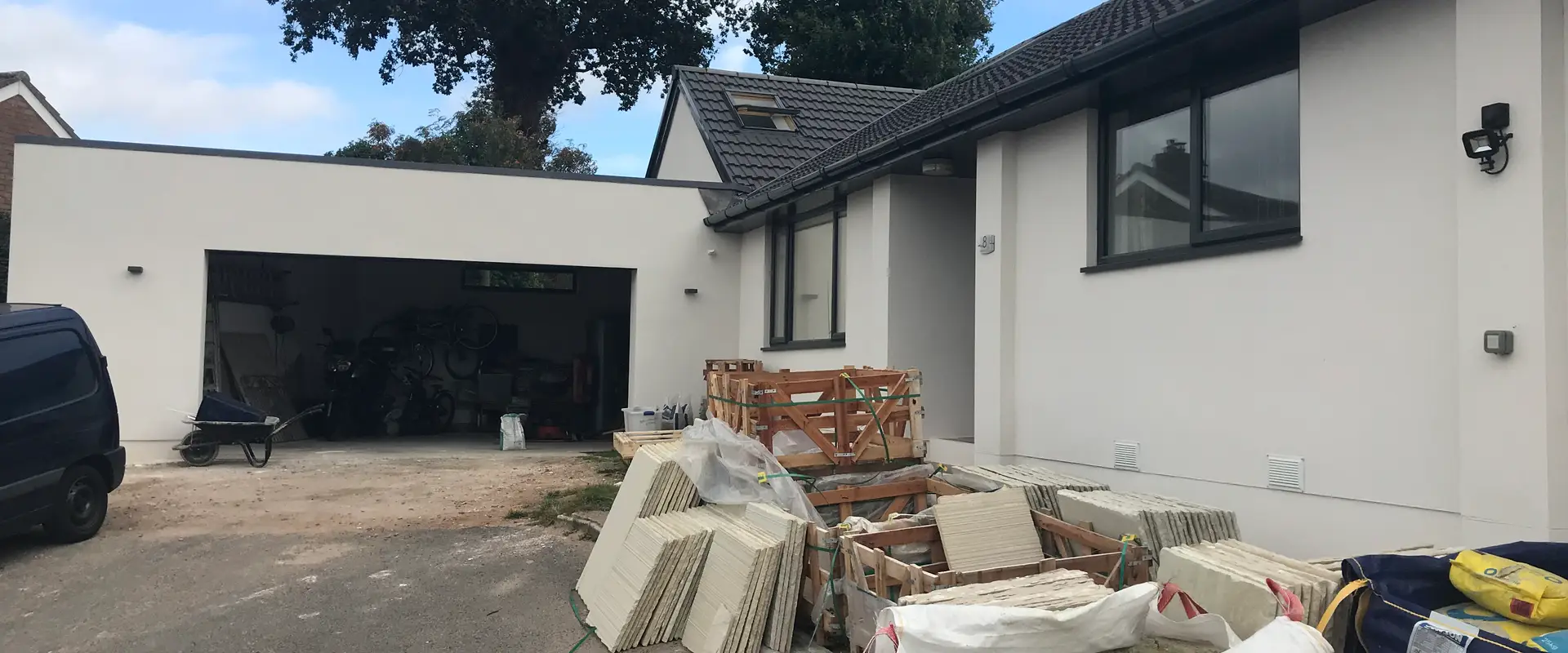 a house with a pile of wood and a garage